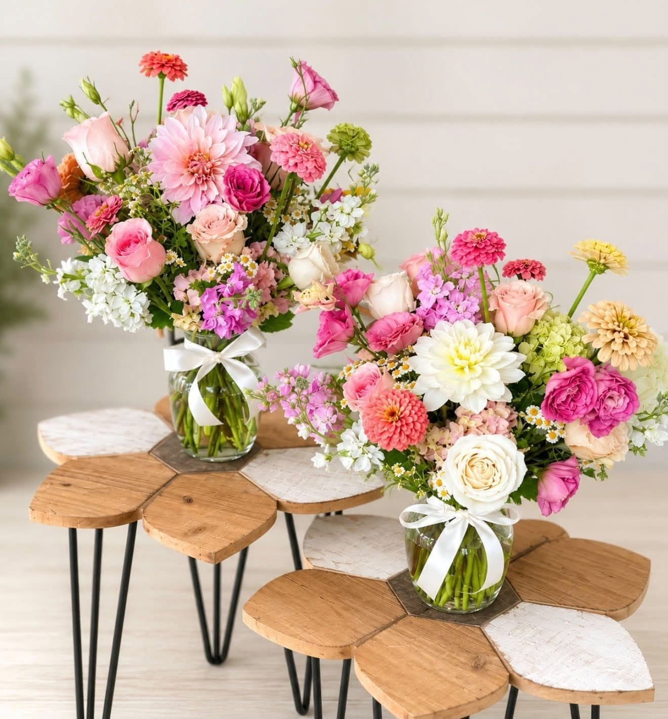 Two pink and white vase arrangements finished with white ribbon