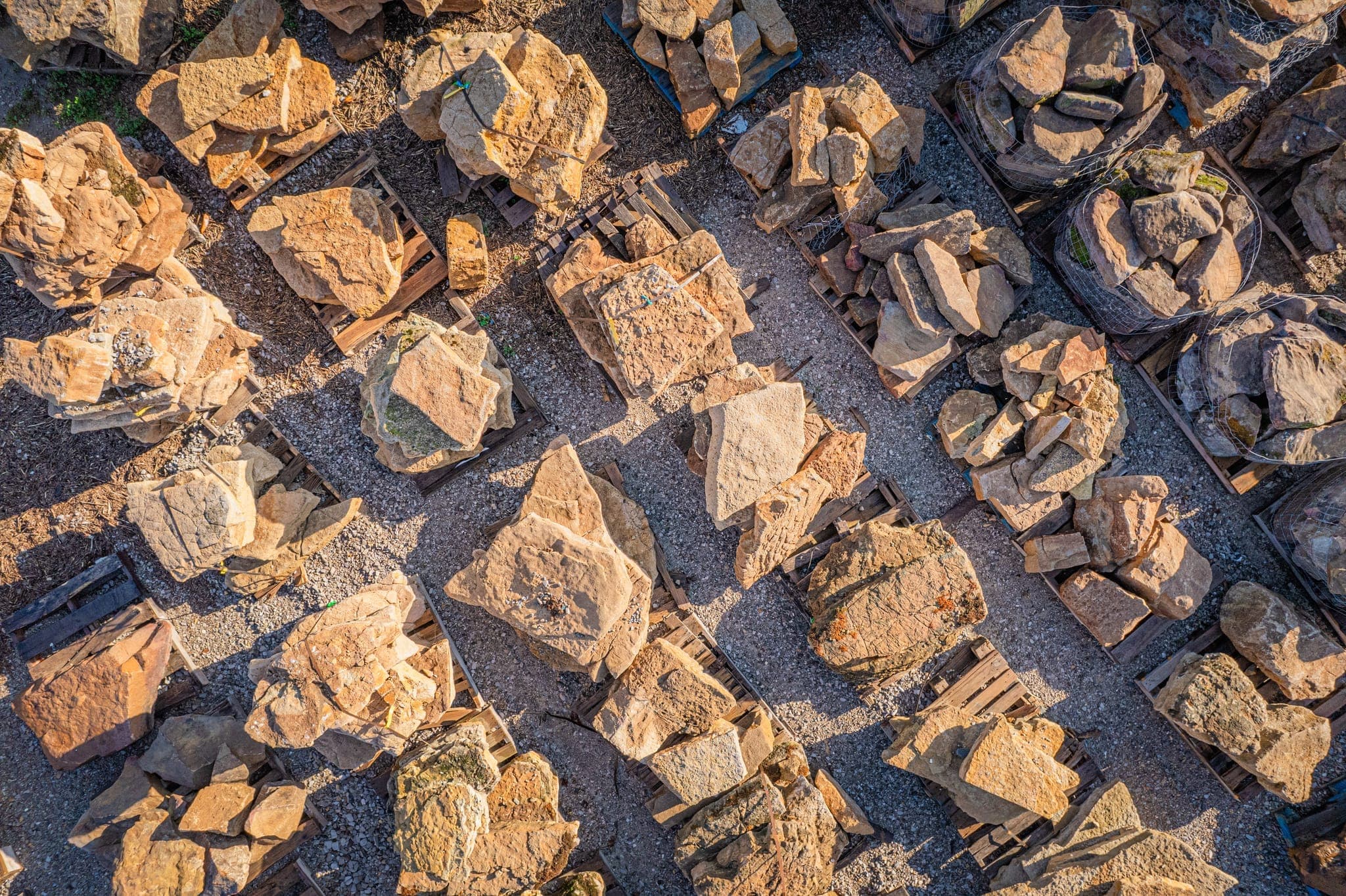 Pallets of decorative stone and gravel options at the materials yard