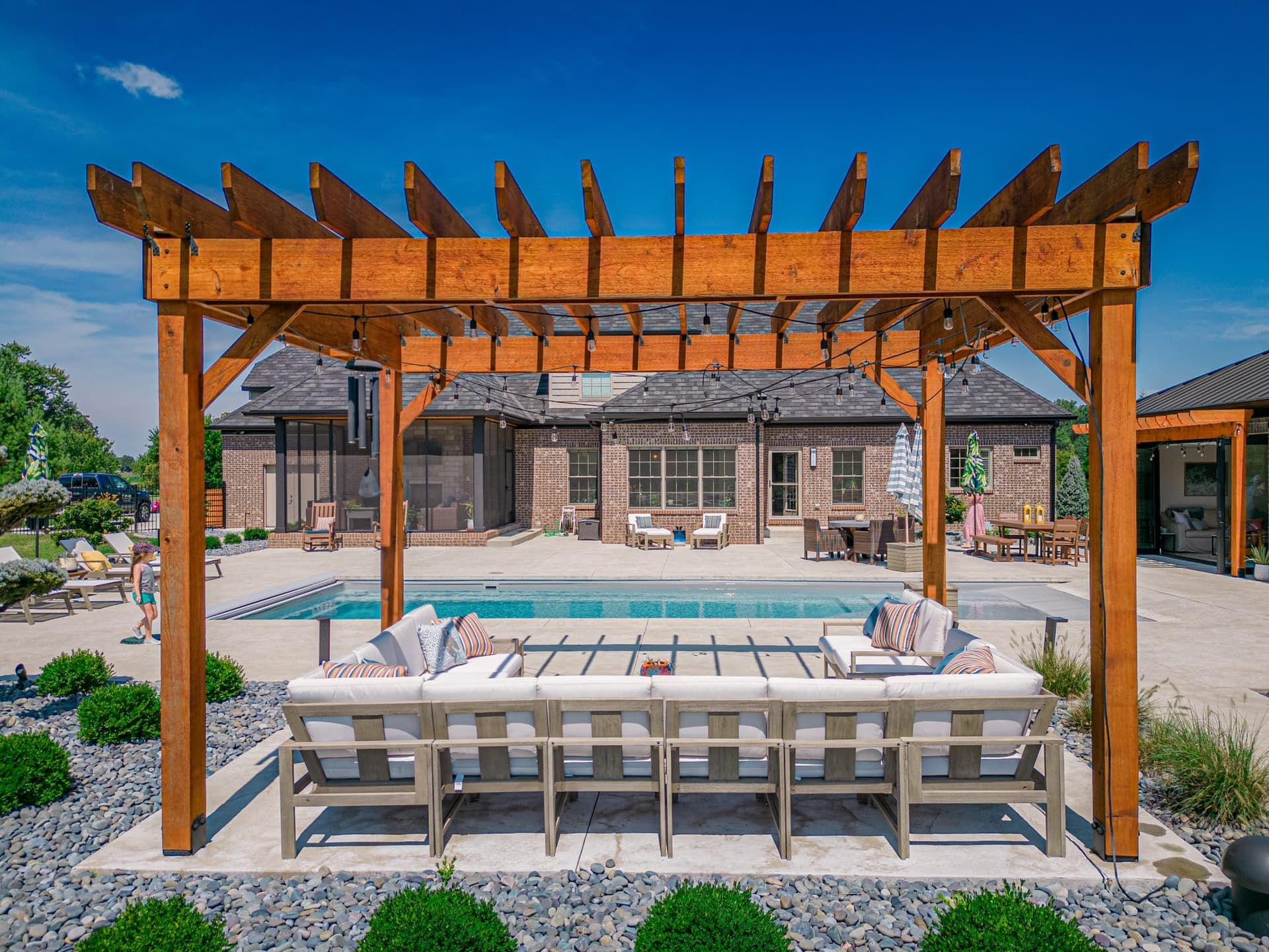 Complete outdoor living space with pergola, pool, patio, and landscaping