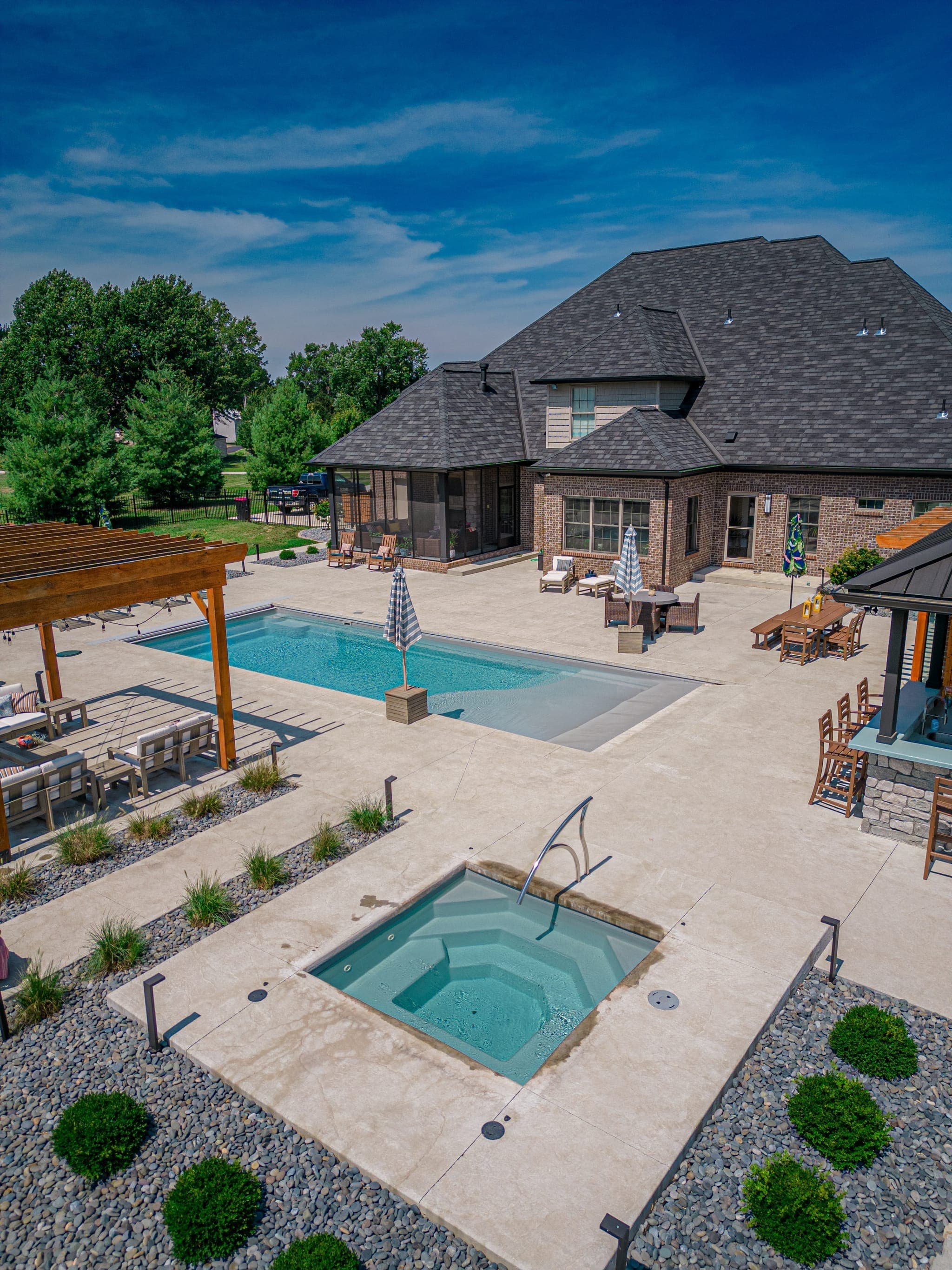 Aerial view of backyard with pool, spa, pergola, and outdoor dining, all built by one team